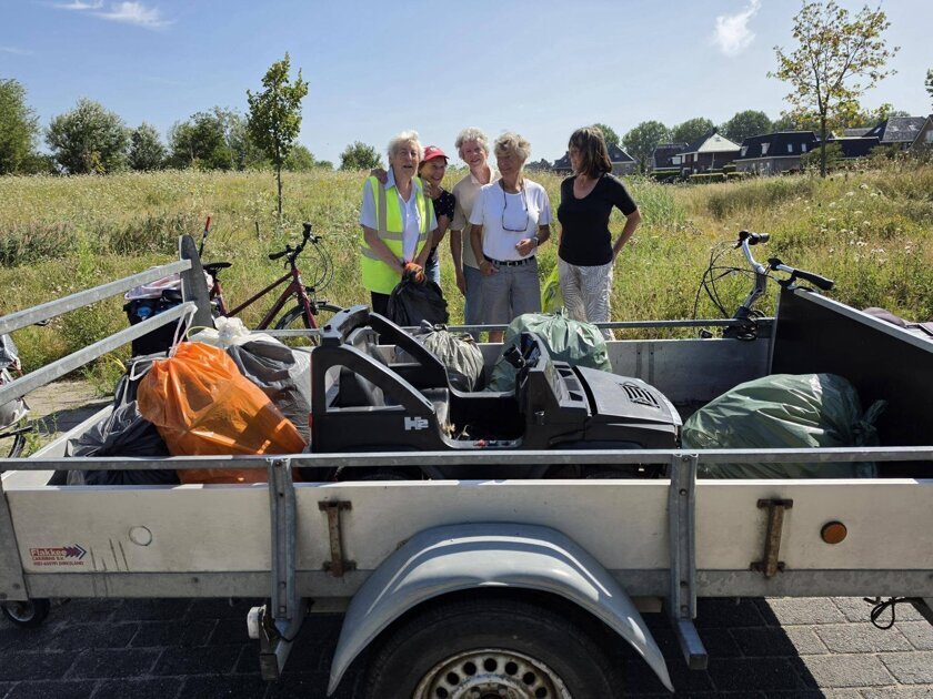 Aanhangwagen vol met afval tijdens schoonmaakactie van Opruimers Hellevoet