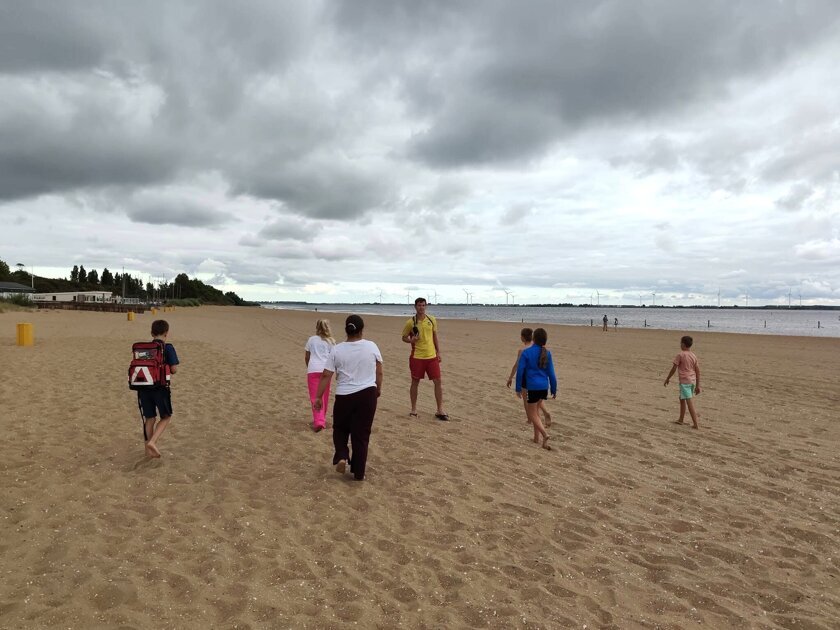 Kinderen maken kennis met het werk van de reddingsbrigade tijdens strandtrainingen